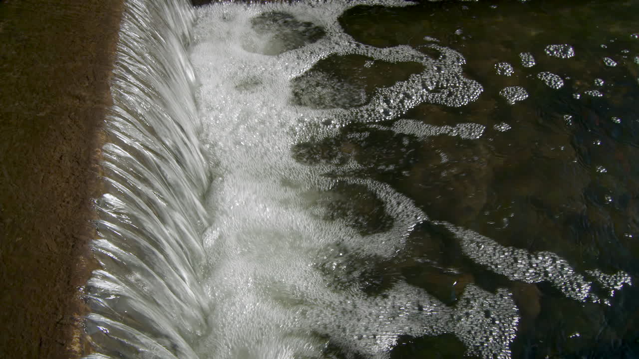 Small Waterfall Flowing Through The Stream. - close up static