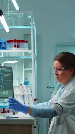 vertical video: medical lab worker analyzing blood serum conducting virus test