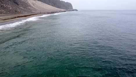 Toma-Aérea-De-Drones,-Drones-Volando-Sobre-El-Océano-A-Lo-Largo-De-La-Carretera-En-El-Parque-Estatal-Point-Mugu,-Santa-Mónica,-California