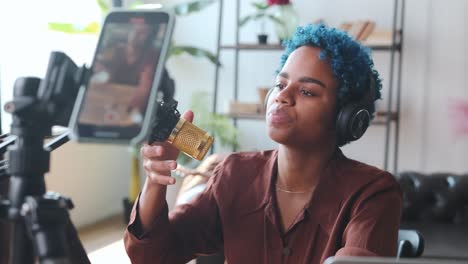 una joven bloguera afroamericana grabando un podcast de video en su teléfono móvil