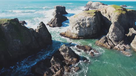 impressive sea cliffs and rocks of bandon oregon with strong waves crashing on sunny day