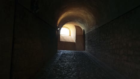 a dimly lit stone tunnel in naples, italy