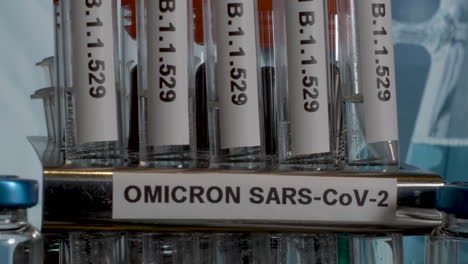 primer plano inclinado de una fila de tubos de ensayo etiquetados con la nueva variante covid 19 omicron, la nueva mutación identificada en sudáfrica b