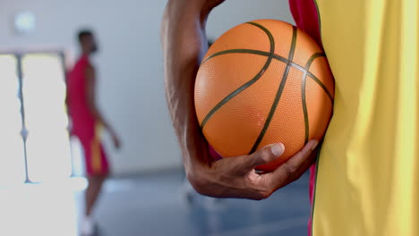 Primer-Plano-De-Una-Pelota-De-Baloncesto-Sostenida-Por-Un-Hombre-Afroamericano