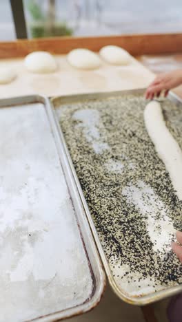 baker preparing bread with sesame seeds