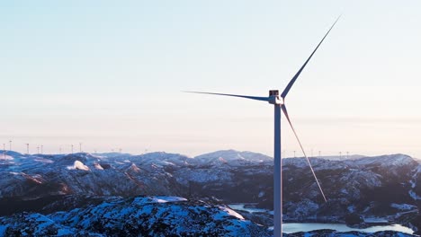 Bessaker,-Condado-De-Trondelag,-Noruega---Turbinas-Eólicas-Situadas-En-Una-Montaña-Cubierta-De-Nieve-Al-Amanecer---Disparo-Aéreo-De-Drones