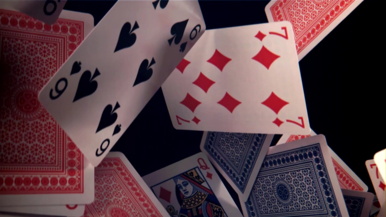 Primo piano di carte da gioco che cadono su uno sfondo scuro