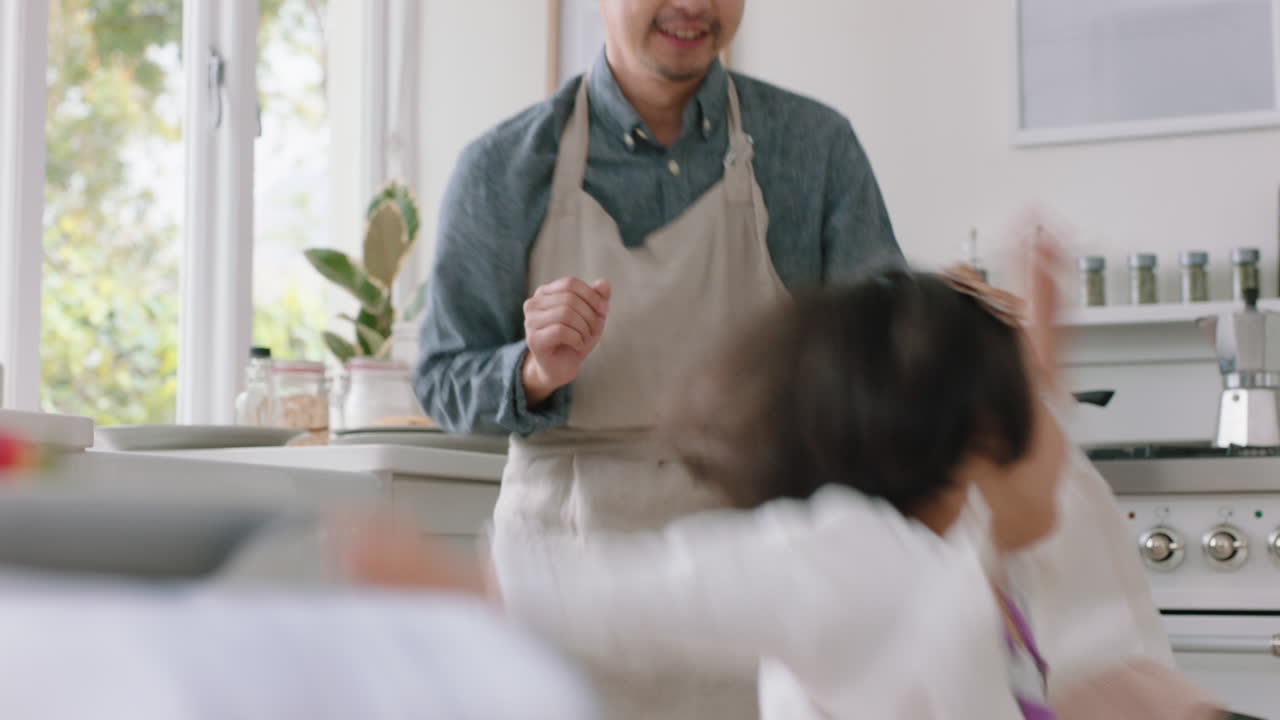 feliz familia asiática bailando en la cocina padre disfrutando de bailar con su hija niña pequeña riendo disfrutando de un emocionante fin de semana en casa 4k metraje