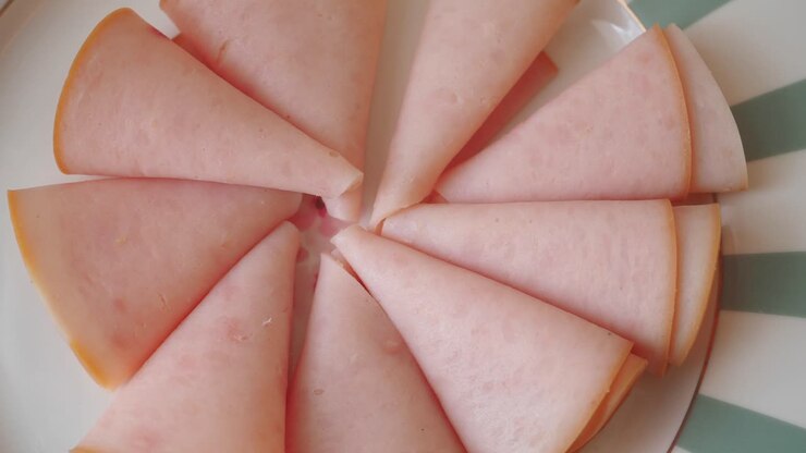 Primo piano di prosciutto affettato disposto su un piatto girevole