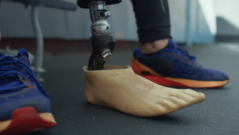 man putting sportshoe on prosthetic foot