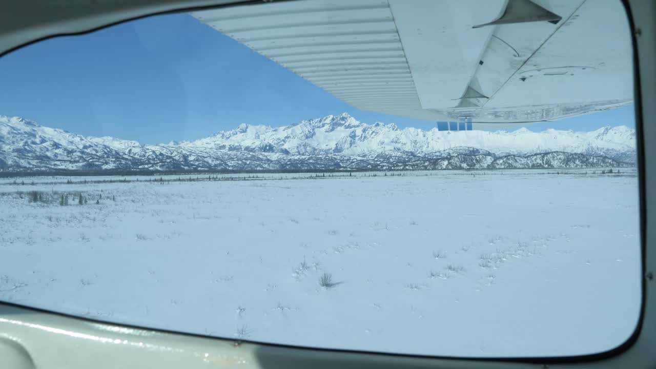Volo sulle acque ghiacciate di Cook Inlet in Alaska durante l'inverno, con vaste distese di foreste innevate, fiumi, valli e cime montuose della catena del Chugach.