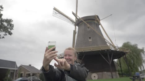 girl takes a selfie with a renovated windmill