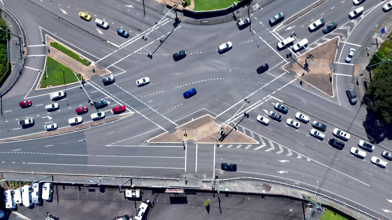 Drone aerial landscape of cars driving across traffic stop lights and main road street at major intersection traffic causeway in Erina Central Coast Australia local transport infrastructure outdoors