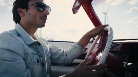 Handheld-video-of--handsome-man-driving-an-antique-car