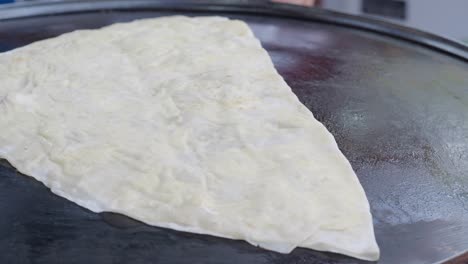 cooking thin dough on a hot griddle