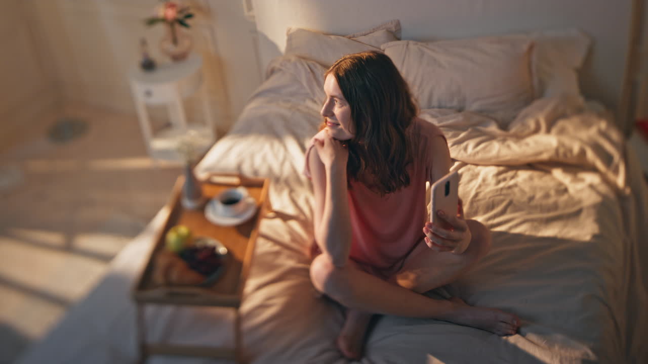 골든 니 침실에서 아침 여성 비디오 전화. 차가운 여자 휴식 호텔