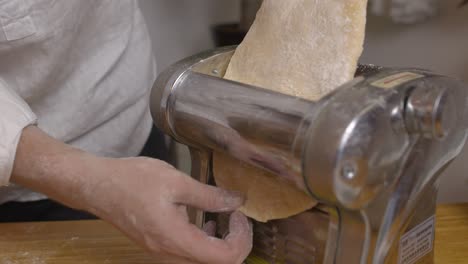 passing lasagna dough through the thinning machine