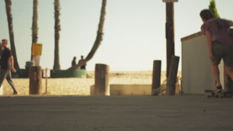 Skateboarder-doing-trick-and-almost-falls-down-in-Los-Angeles-coastline