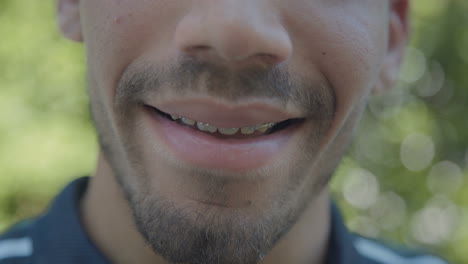 primer plano de la boca de un joven caucásico sonriente con corchetes