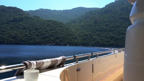 forested island seen from yacht at sea on a sunny summer's day