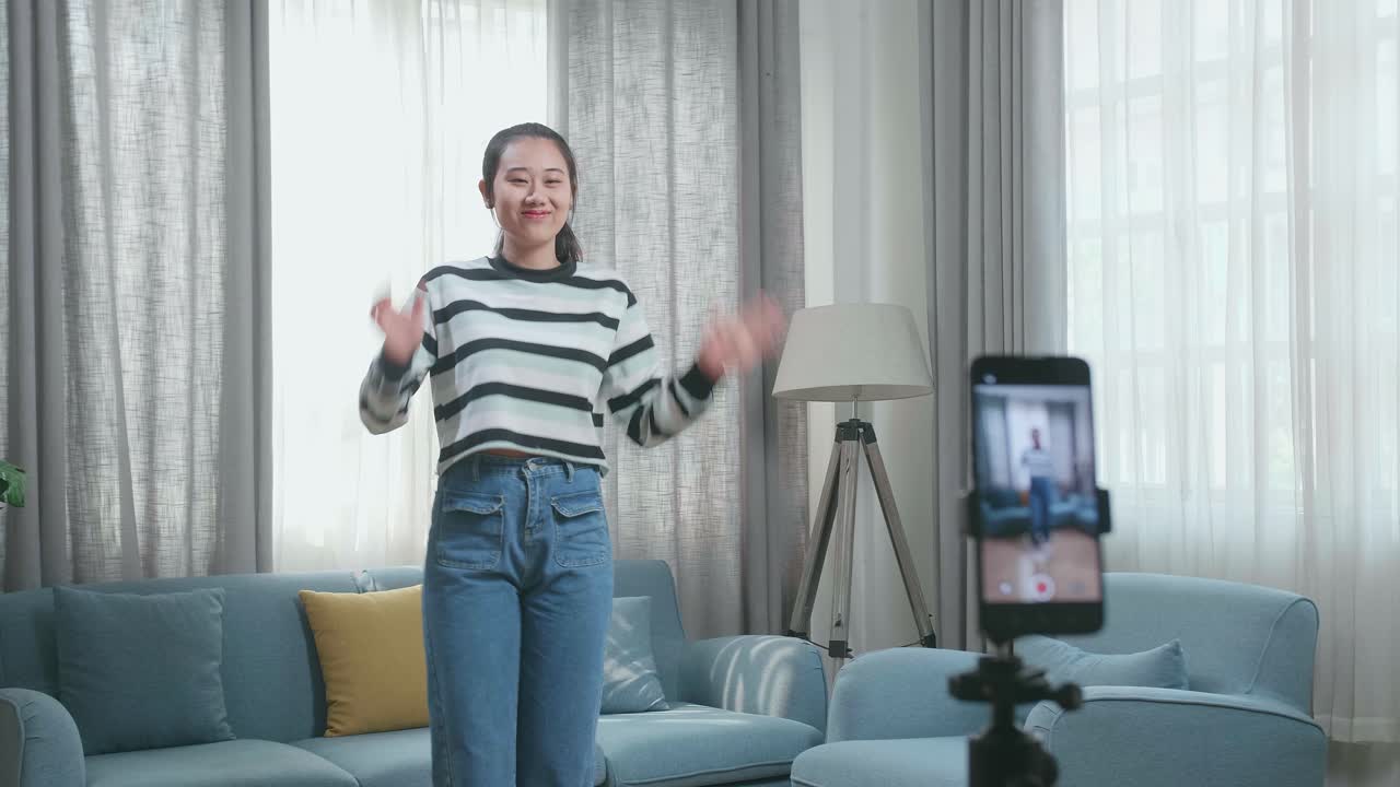 Asian Woman Dancing While Shooting Video Content For Social Networks With A Smartphone Camera