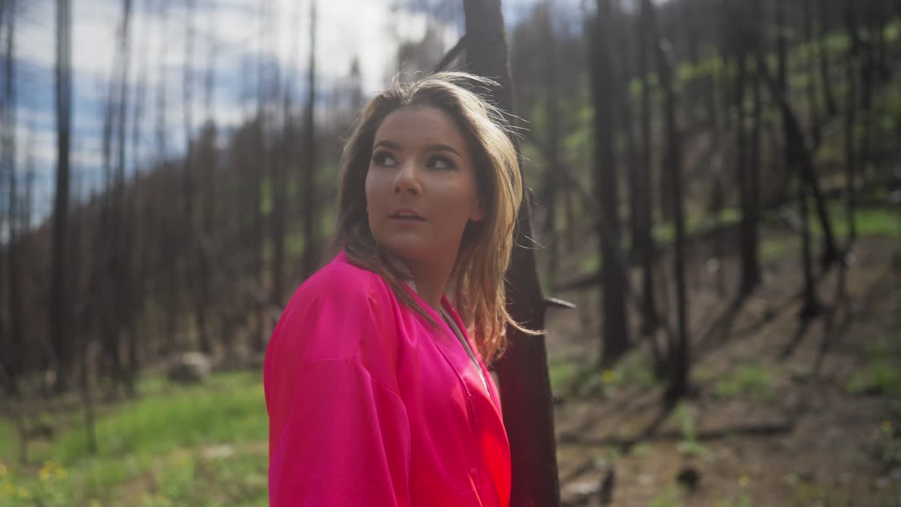 mujer tranquila de color rosa caminando por los árboles