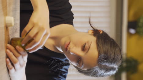 Vertical-video-of-The-young-woman-who-looks-at-the-pills-in-her-hand.