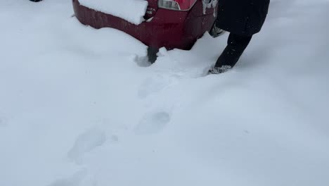 girl walking in deep snow to a car