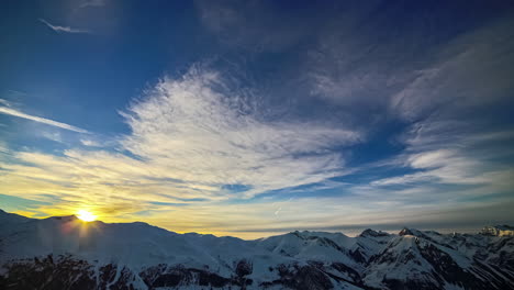 aerial timelapse of sunset over mountans covered with snow in timelapse