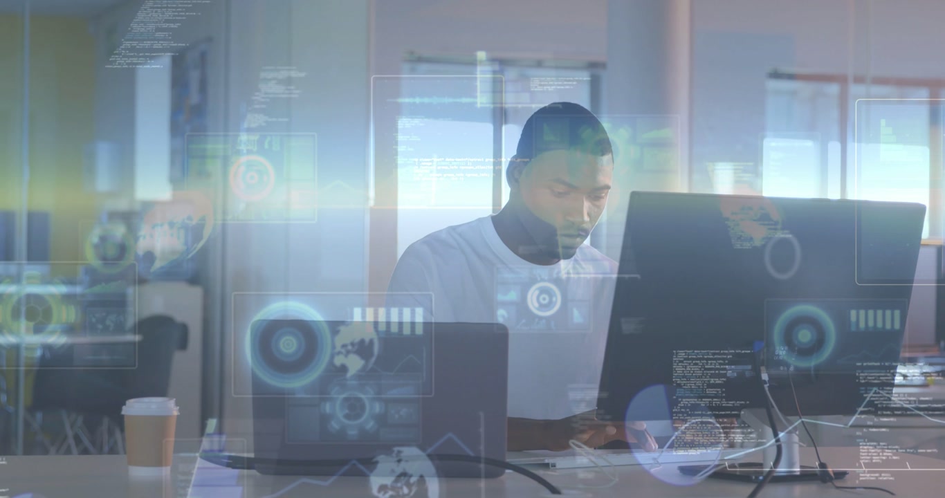 Vertical video: Typing man in white tee analyzing data at office desk with laptop and HUD appearing