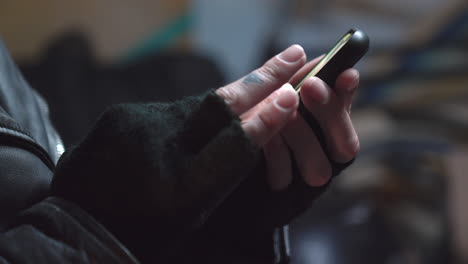 a person using a phone while wearing black fingerless gloves