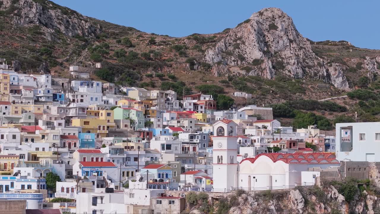 Drone footage orbit capturing the traditional colorful houses and unique charm of Menetes Village on Karpathos Island, a scenic Greek island destination