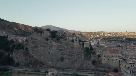 el sol se pone en una ciudad construida en los antiguos acantilados del sur de italia.