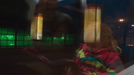 vista nocturna de la ciudad en la ventana del tren con el reflejo de la madre y el niño