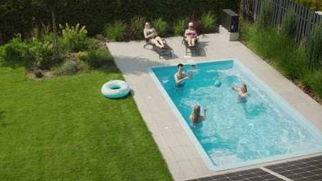 Una-Familia-Alegre-Se-Relaja-En-La-Piscina-En-El-Patio-Trasero-De-Una-Villa.-Caluroso-Día-De-Verano