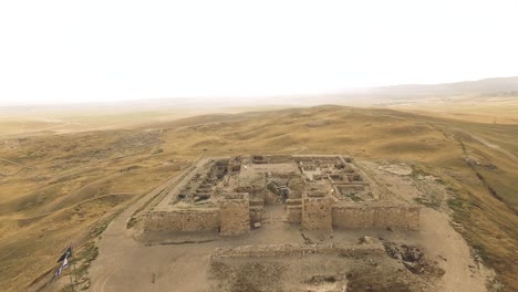 antiguo fuerte arruinado en la cima de una pequeña montaña en medio del desierto