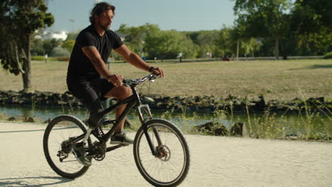 Totale-Aufnahme-Eines-Konzentrierten-Mannes-Mit-Beinprothese,-Der-Im-Park-Fahrrad-Fährt