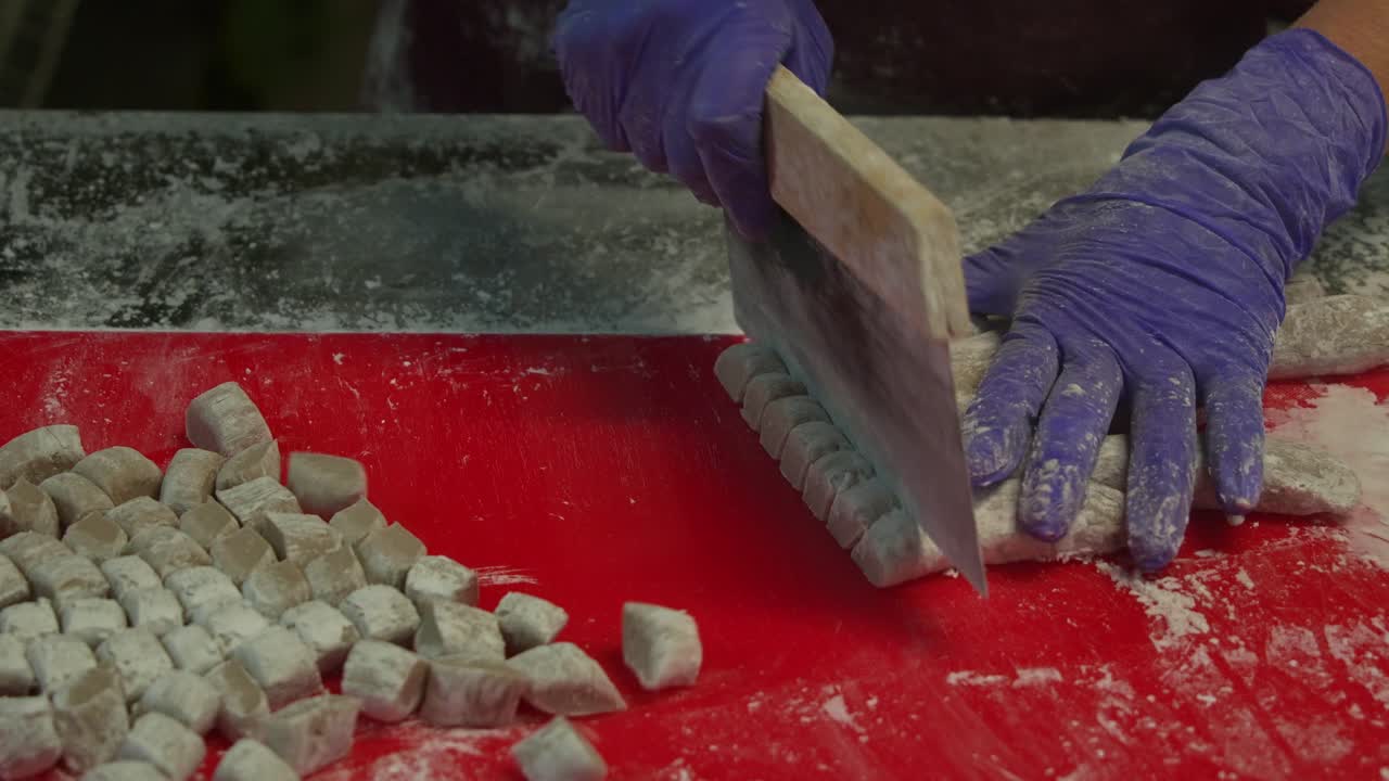 después de enrollar la masa de taro en formas cilíndricas, se corta usando un cortador de masa en pequeñas porciones, preparación de bolas de ñame, el popular postre tradicional taiwanés