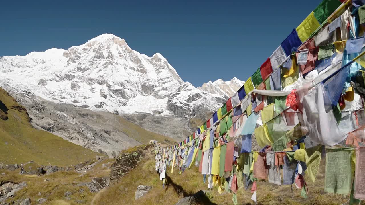 banderas de oración en las montañas nevadas de nepal, banderas de oración budistas tibetanas coloridas en el cielo azul en un día soleado en los himalayas en annapurna, banderas budistas coloridas en la naturaleza con montañas nevadas