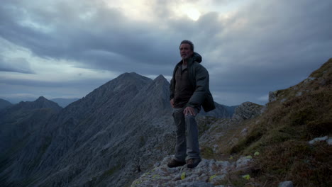 a man stands on a mountaintop overlooking a vast landscape