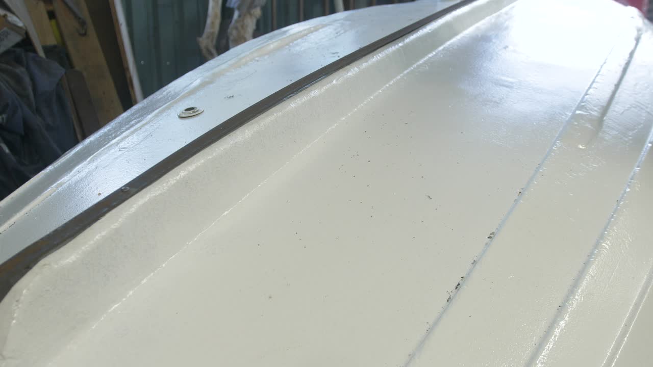 Brushing debris dust off fiberglass boat bottom hull