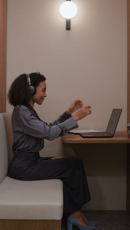 woman working on laptop with headphones in office