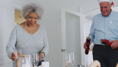 Senior-Couple-At-Home-Setting-And-Decorating-Table-For-Meal-On-Christmas-Day