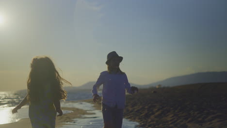 niños jugando en la playa al atardecer