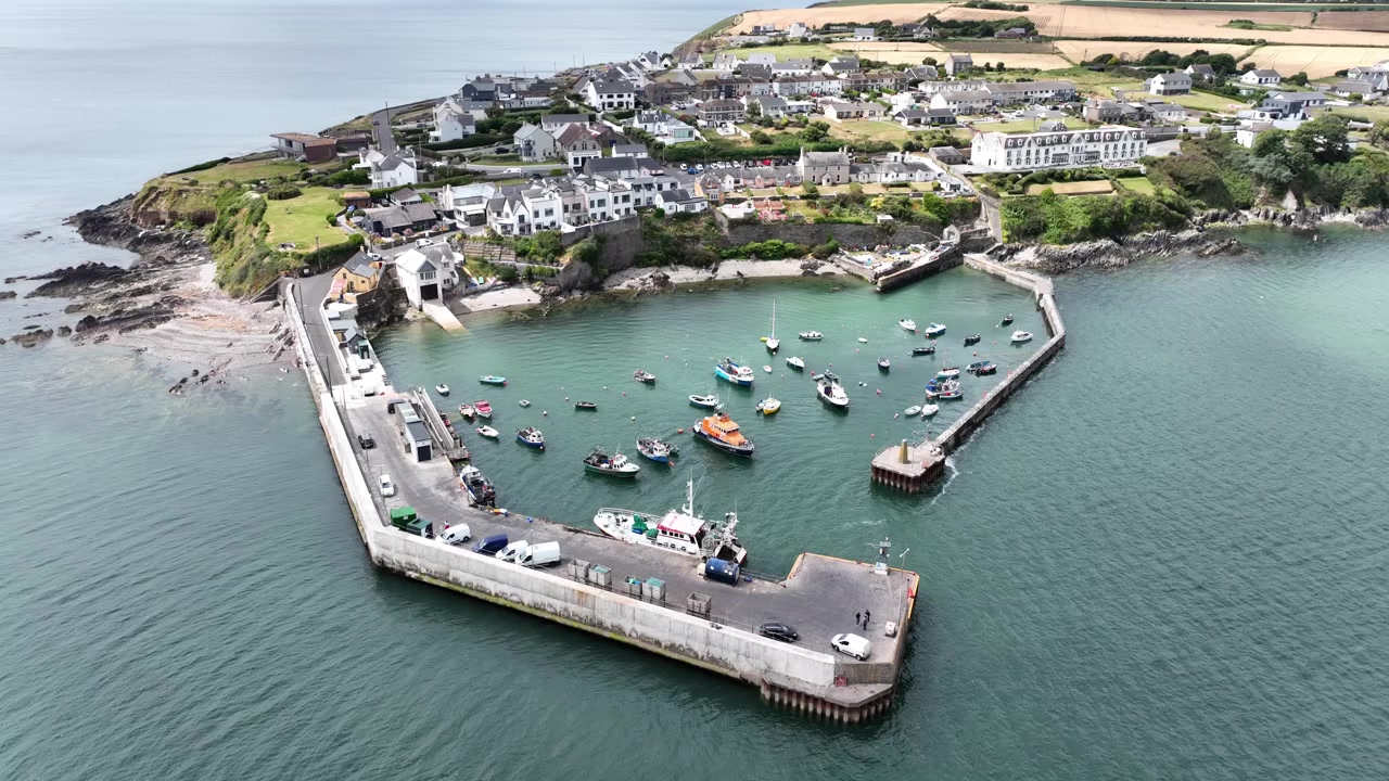 Incredibili riprese aeree Irlanda: scatto statico con drone del villaggio e del porto di Ballycotton, con la scialuppa di salvataggio di Ballycotton ormeggiata nel porto