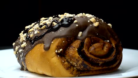 a chocolate roll is pouring by hot melted cocoa.