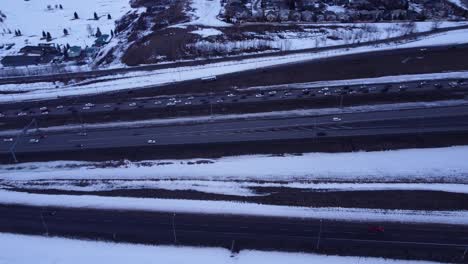 Imágenes-De-Drones-Aéreos-Al-Atardecer-De-Una-Carretera-Cubierta-De-Nieve-Helada-Con-Autos