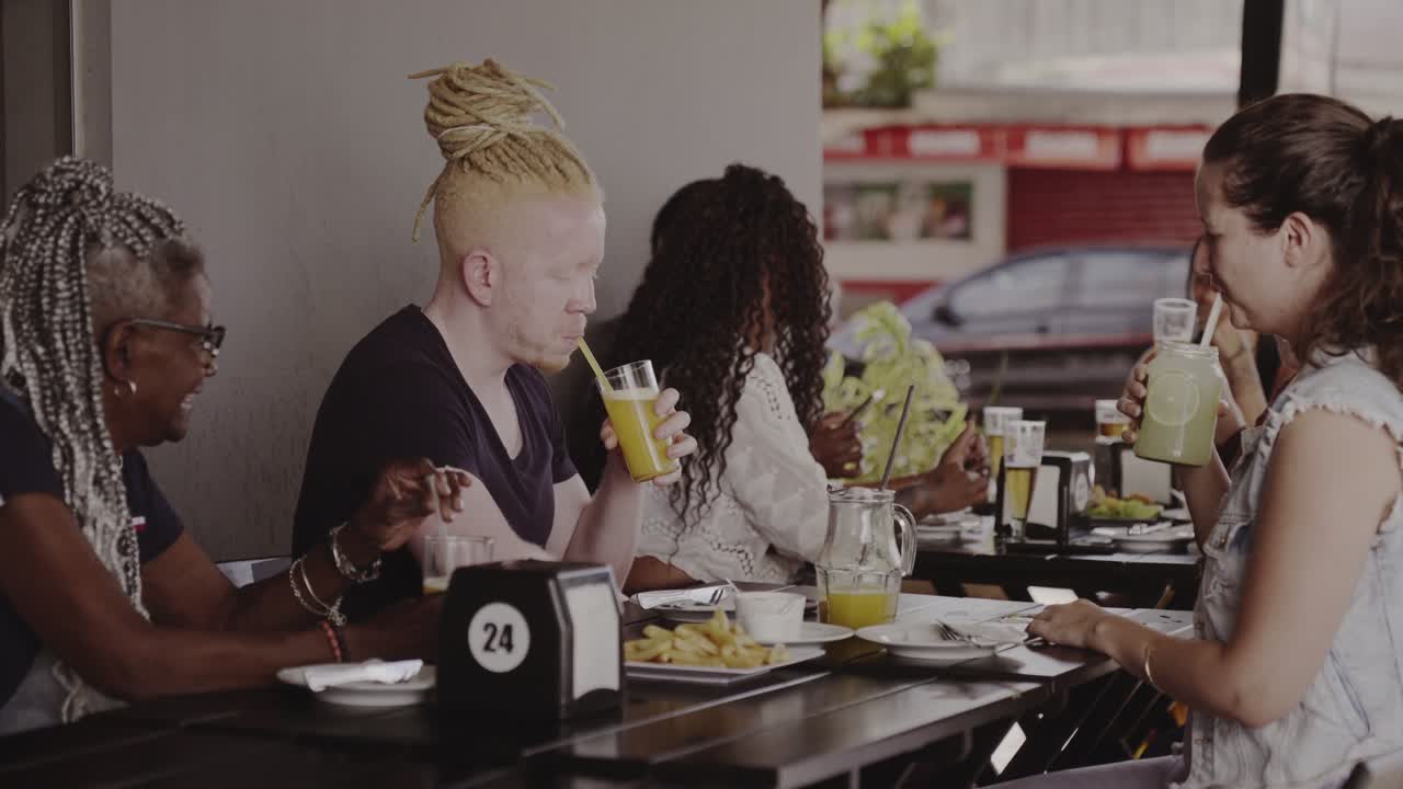 Diverse group of friends dining and socializing at an outdoor restaurant