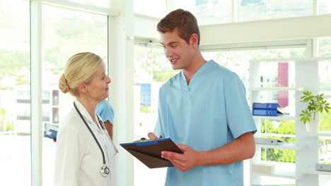 Two-doctors-working-with-clipboard-and-looking-at-camera-