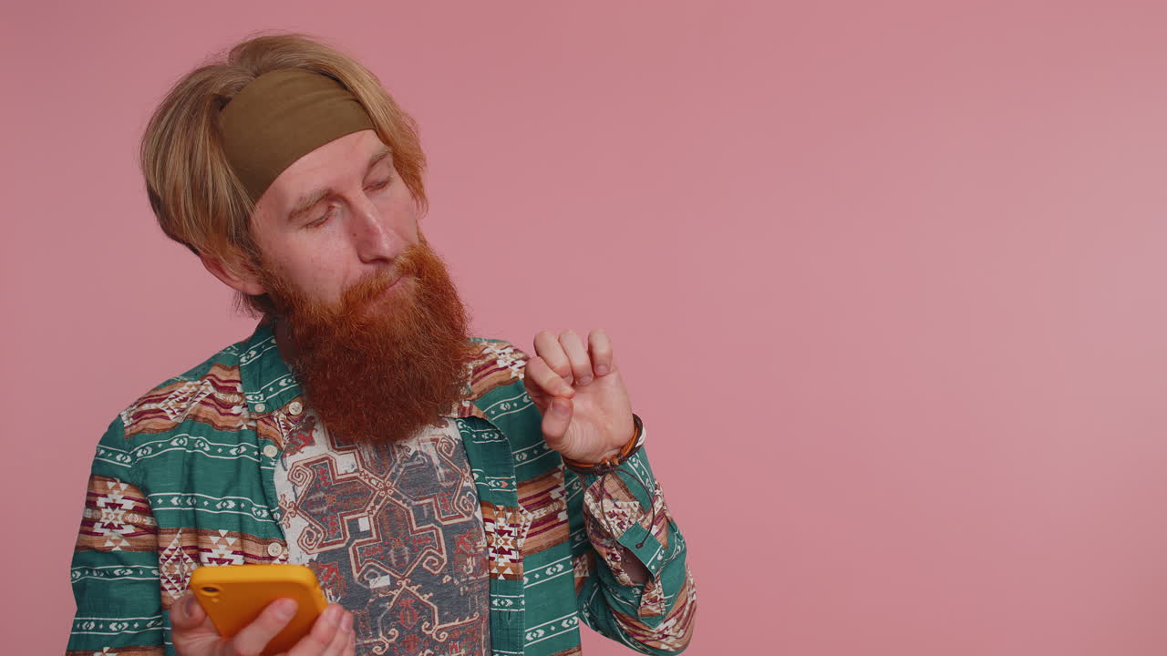 hombre hippie uso de teléfono inteligente, pulgares hacia arriba como, retroalimentación positiva, recomienda, área de publicidad vacía